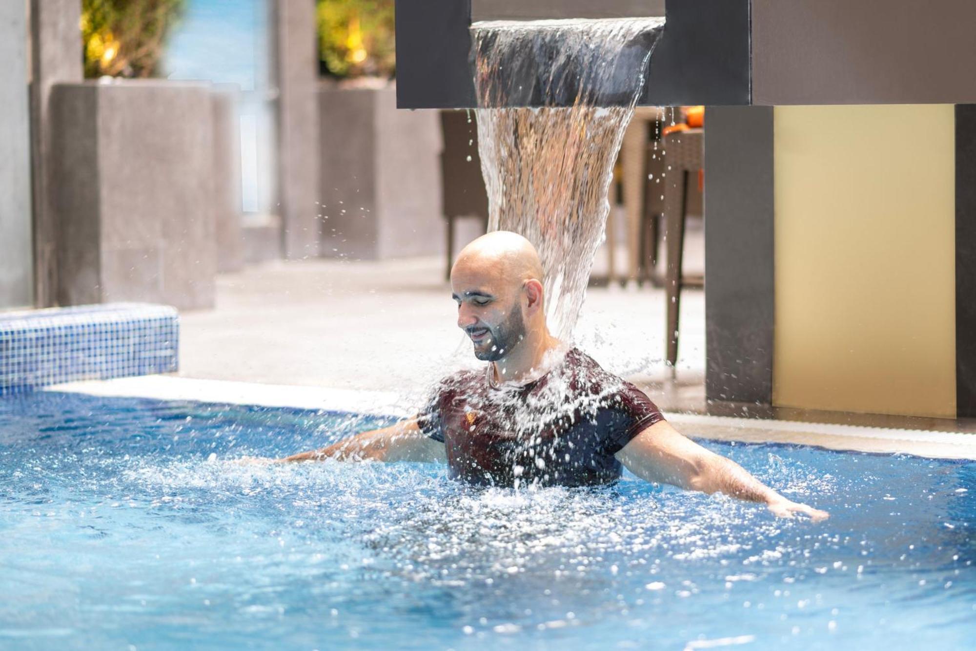 Delta Hotels By Marriott City Center Doha Extérieur photo A man swimming in a pool